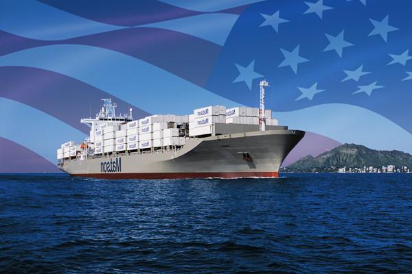 hg体育船装载着抵达檀香山的集装箱，背景是强加的美国国旗.
